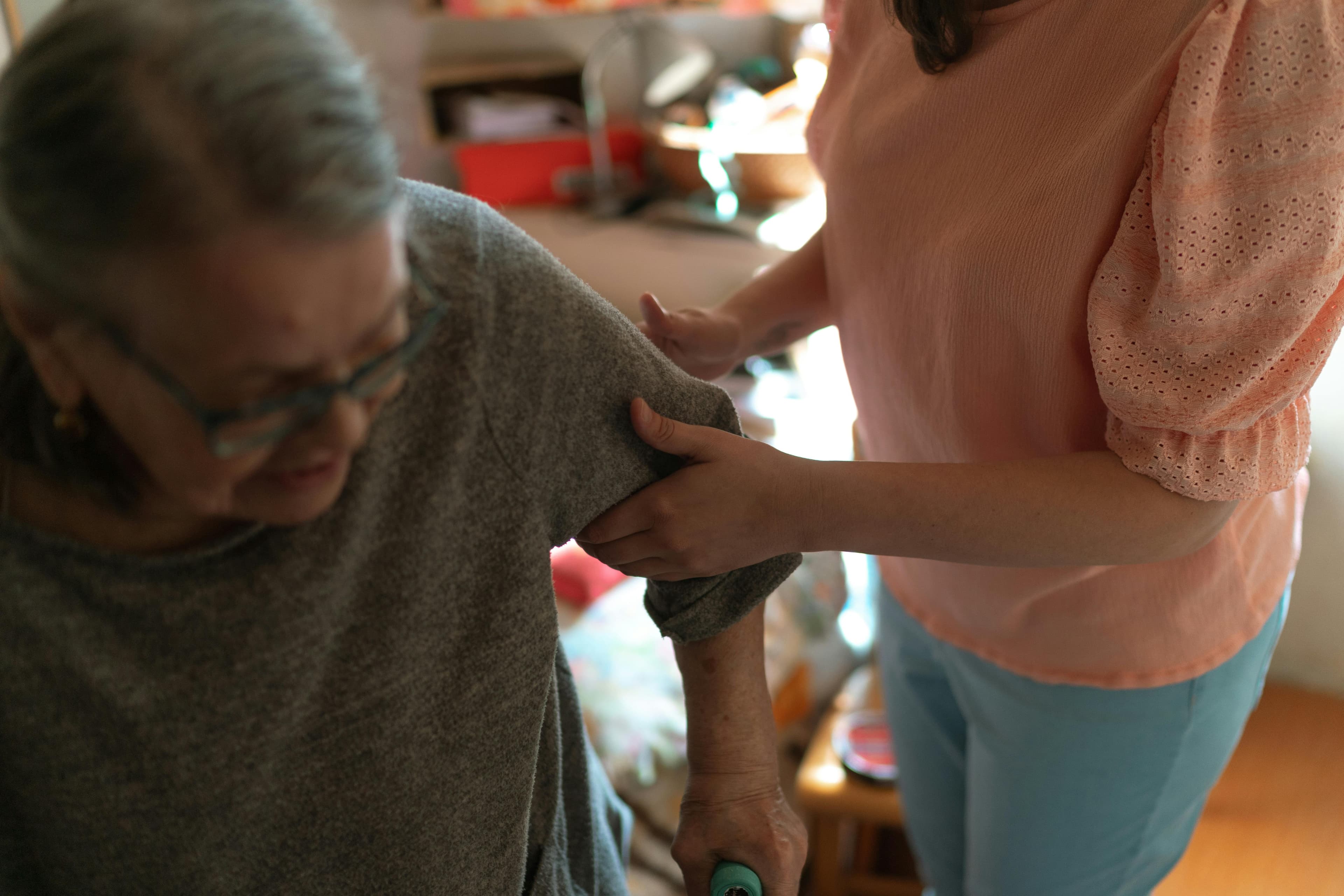 Lady cutting grandma's hair at home providing personal grooming care